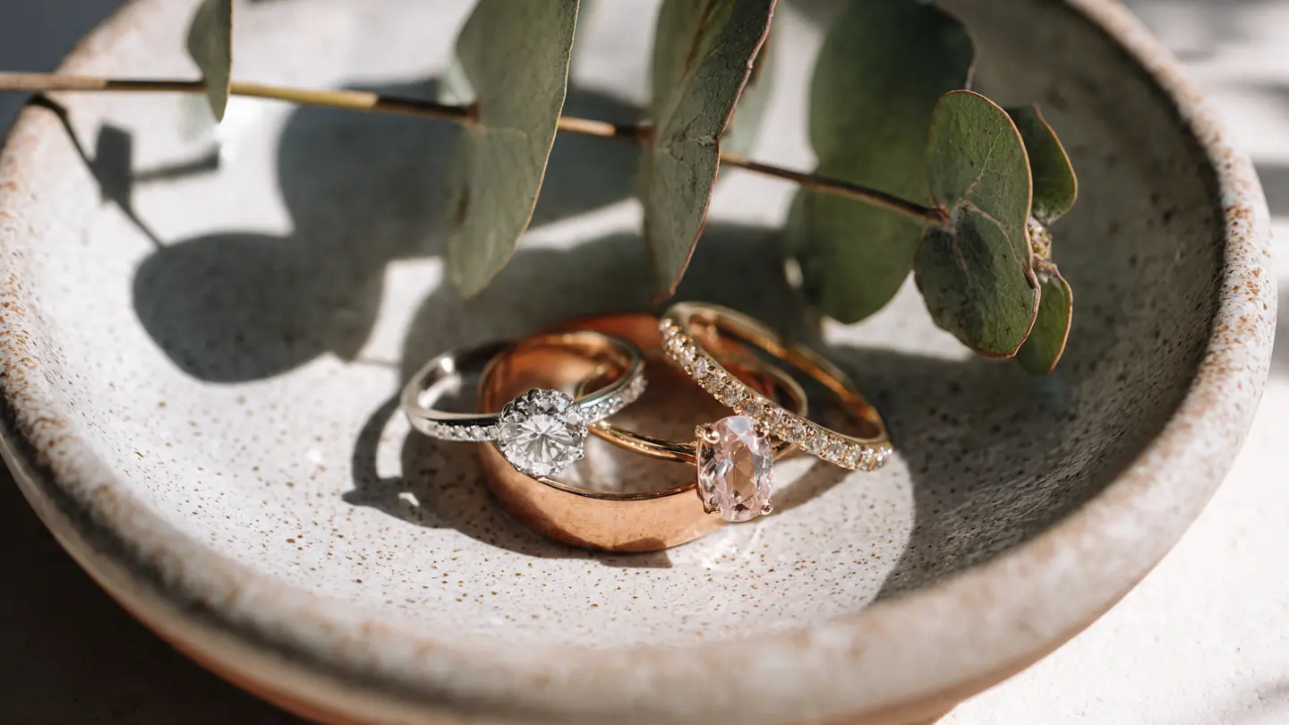 A variety of budget-friendly engagement rings including salt-and-pepper diamonds and morganite on a minimalist tray